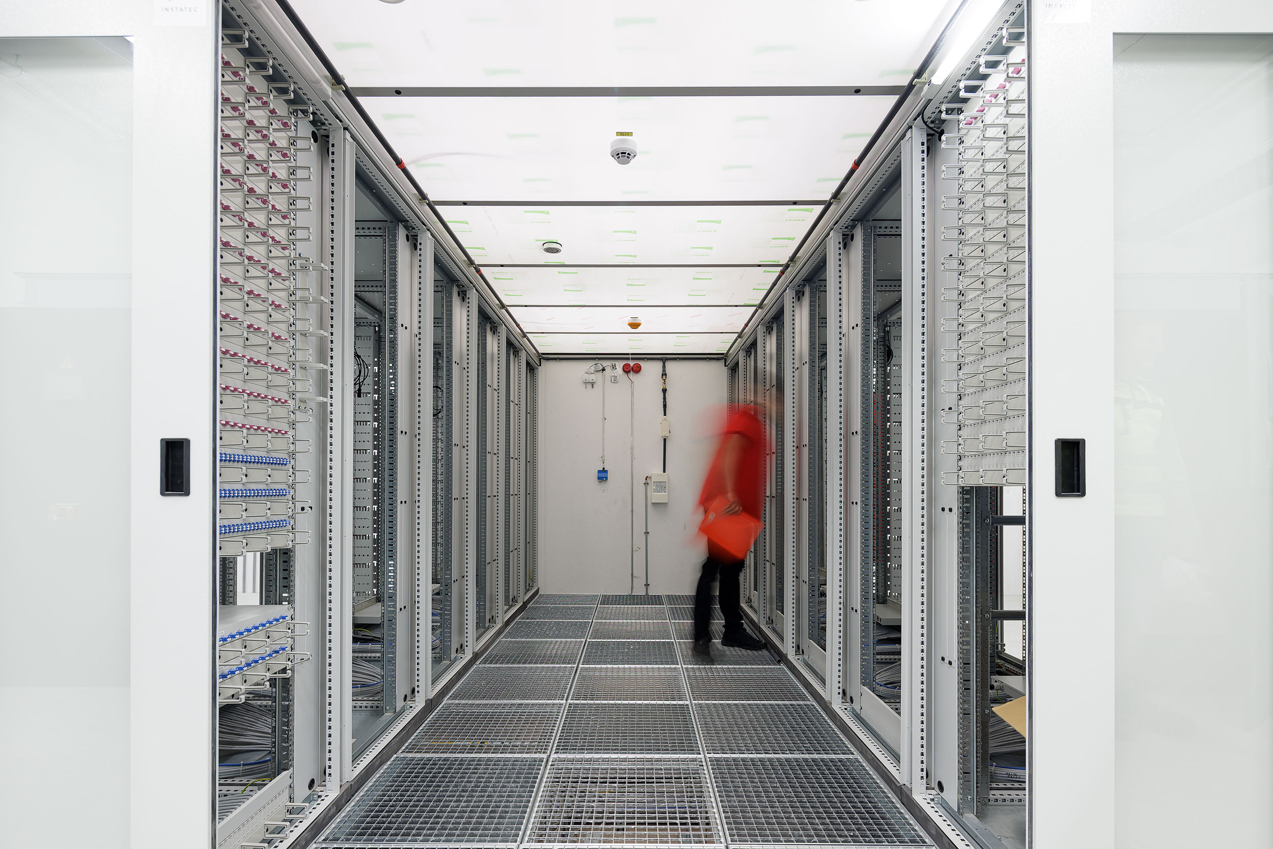 Serverschränke und Netzwerktechnik in einem Technikraum zur sicheren Datenübertragung und IT-Infrastruktur in gewerblichen Gebäuden.